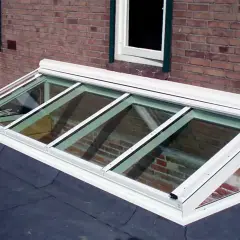 Monteras para patios, un tragaluz moderno de vidrio y aluminio sobre un tejado, ilumina el interior con luz natural.