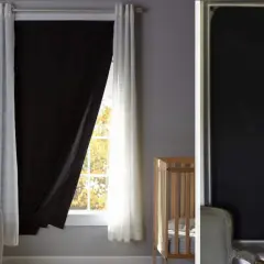 Habitación infantil con cuna y una ventana sin persiana, cubierta por cortinas blancas y un panel negro para oscurecer.