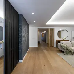 Cocina moderna y salón con sofá beige. El suelo de madera y la decoración crean un ambiente acogedor. Ideal para calcular el precio reforma integral.