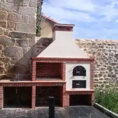 Barbacoa de ladrillo con horno de leña y fregadero, lista para hacer barbacoas y disfrutar del buen tiempo.