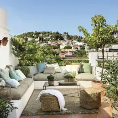 Un rincón perfecto para **chill out** en la **terraza**, con cómodos cojines, plantas y vistas a la ciudad.