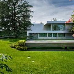 Modern villa con piscina y jardines impecables, un ejemplo de patios de lujo.