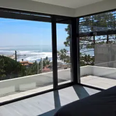 Ventana con vistas al mar, ideal para inspirar ideas para decorar ventanas. El interior minimalista contrasta con el paisaje exterior.
