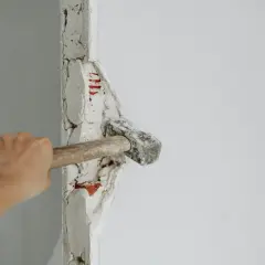 Mano golpeando un tabique con un mazo. ¡Demostrando que puedo tirar un tabique yo mismo!