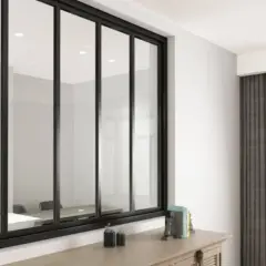 Amplio ventanal con **vidrio laminado de seguridad** y marco negro, reflejando una sala de reuniones. Cortinas grises y una planta adornan el espacio.