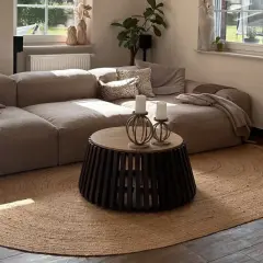 Alfombra redonda de yute, uno de los tipos de alfombras más naturales y versátiles, complementa un salón moderno con sofá modular y mesa de centro.
