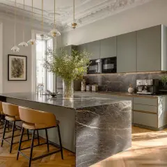 Cocina moderna con isla de mármol y taburetes. Un ejemplo perfecto de cuanto se revaloriza un piso reformado con estilo y acabados de lujo.