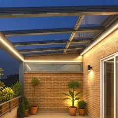 Moderna terraza ático con iluminación LED integrada, plantas en macetas y vistas al anochecer.
