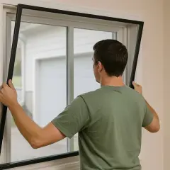 Hombre instala un marco para ventanas insonorizadas, mejorando el aislamiento acústico del hogar.