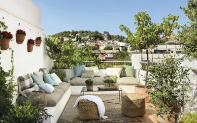 Un rincón perfecto para **chill out** en la **terraza**, con cómodos cojines, plantas y vistas a la ciudad.