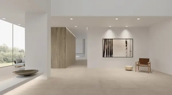Amplio salón moderno con suelo de baldosas de piedra natural, ideal como mejor suelo para casa. Muebles minimalistas y arte abstracto.