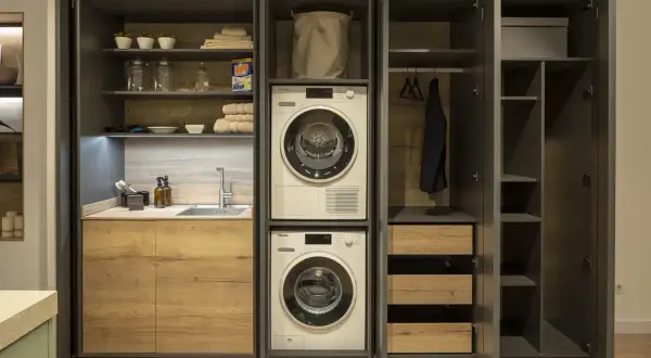 Lavaderos con encanto: lavadora, secadora, fregadero y armarios de madera. Todo organizado para un espacio funcional y estético.