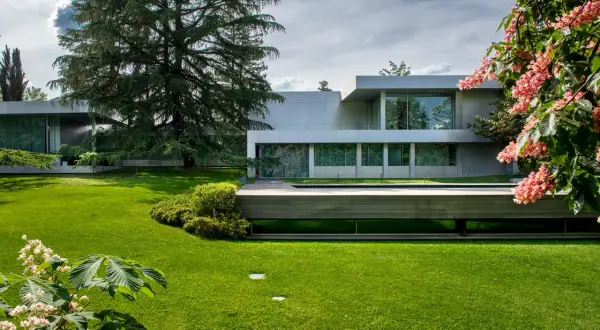 Modern villa con piscina y jardines impecables, un ejemplo de patios de lujo.
