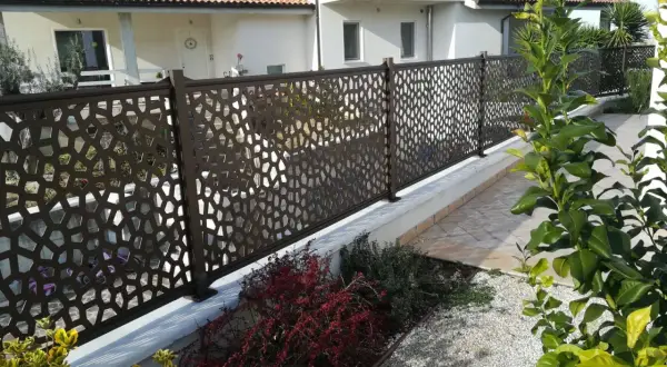 Modern metal fence with geometric cutouts, offering privacy and style. Perfect for **ideas ocultación jardin** and creating a chic outdoor space.