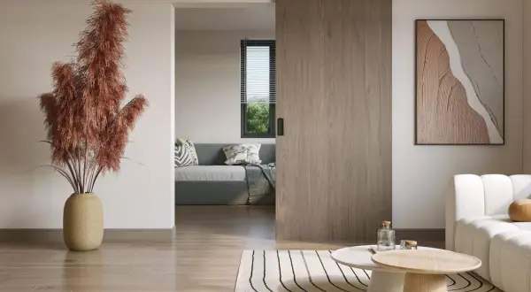 Instalar puerta corredera de madera en un salón moderno. Un jarrón con pampas secas decora el espacio.