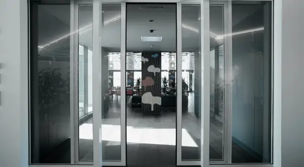 Modern interior with automatic, floor-to-ceiling ventanas correderas o abatibles, revealing a vibrant dining area with cloud-themed decor.