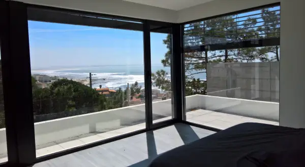 Ventana con vistas al mar, ideal para inspirar ideas para decorar ventanas. El interior minimalista contrasta con el paisaje exterior.