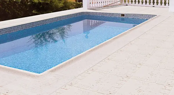 Piscina con suelos para piscinas que no quemen, de tonos claros y textura agradable.