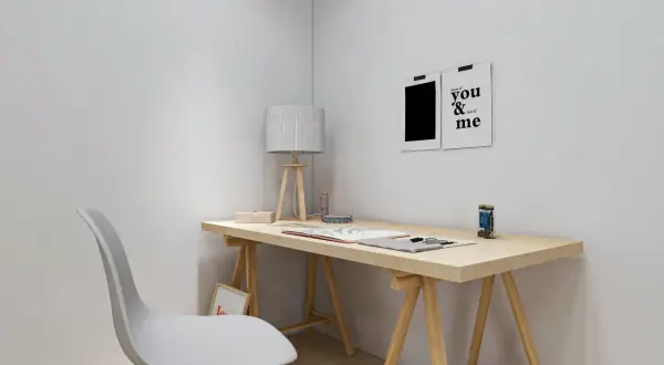 Un escritorio minimalista con tablero de madera, una silla blanca y dos cuadros decorativos. Ideal para hacer escritorio con tablero y crear un espacio de trabajo inspirador.