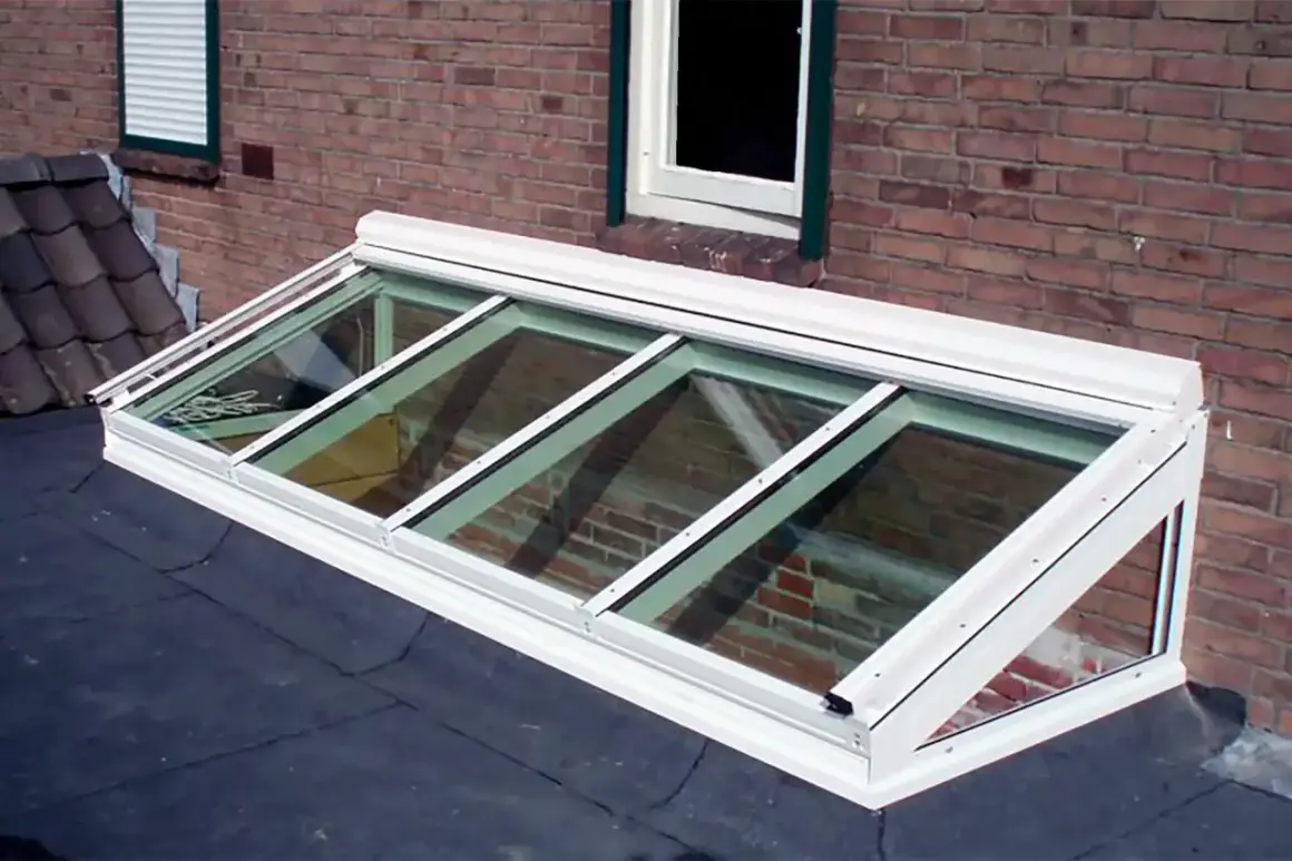 Monteras para patios, un tragaluz moderno de vidrio y aluminio sobre un tejado, ilumina el interior con luz natural.