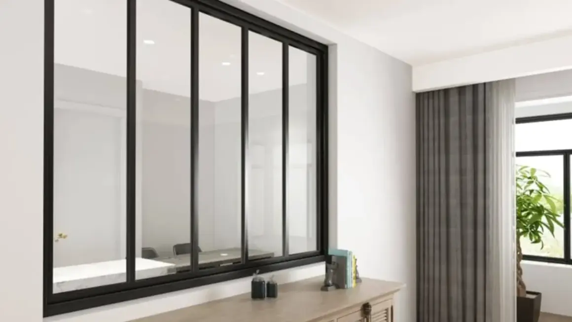Amplio ventanal con **vidrio laminado de seguridad** y marco negro, reflejando una sala de reuniones. Cortinas grises y una planta adornan el espacio.