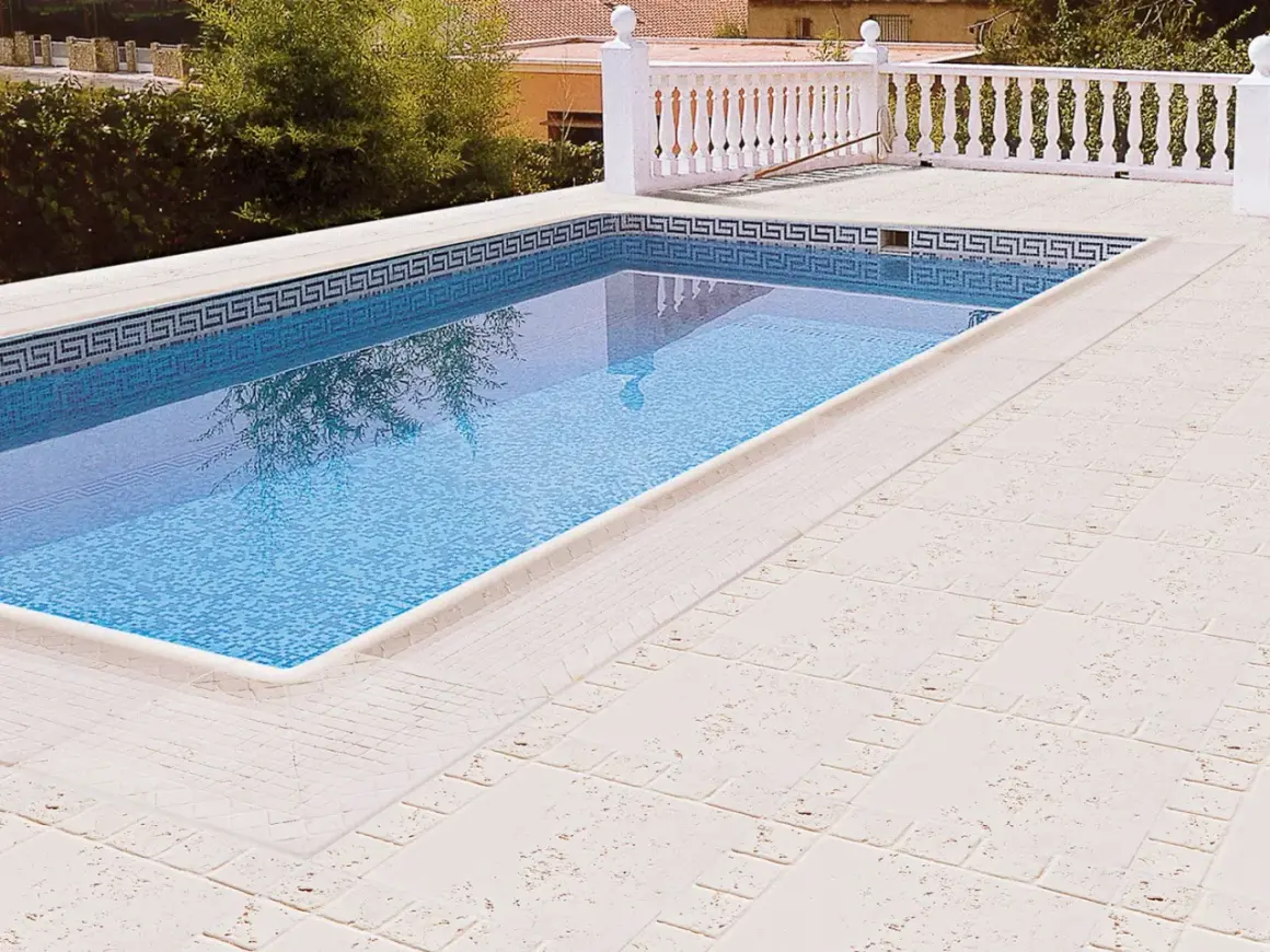 Piscina con suelos para piscinas que no quemen, de tonos claros y textura agradable.