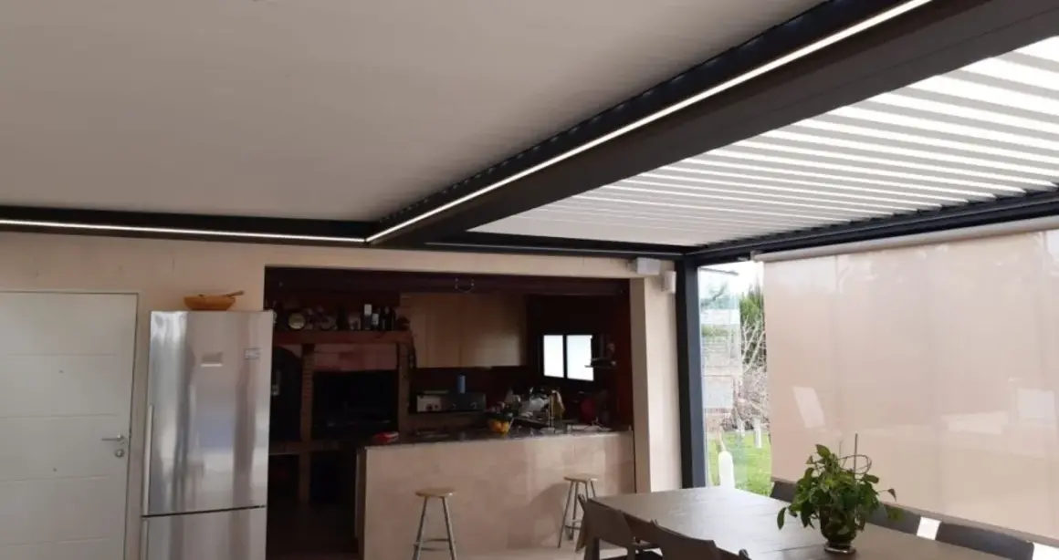 Un moderno patio de luces con normativa de iluminación LED integrada, que ilumina una cocina exterior y zona de comedor.