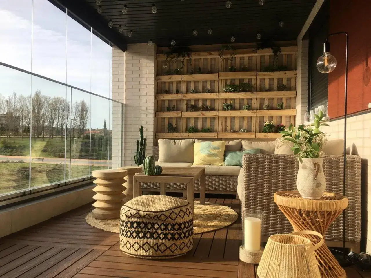 Un rincón perfecto para chill out terraza con sofá, cojines, plantas y vistas al exterior.