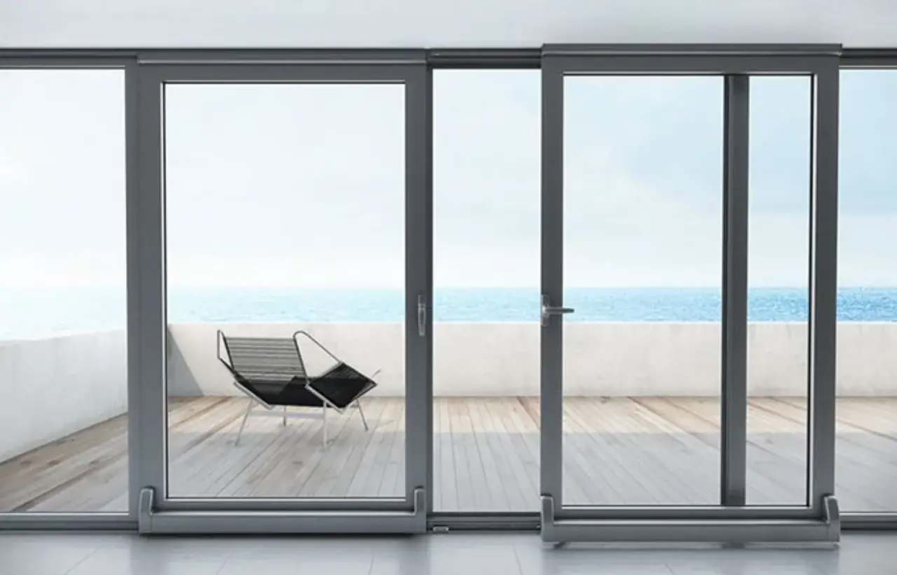 Ventanas osciloparalelas con vista al mar. Una silla moderna en la terraza de madera.