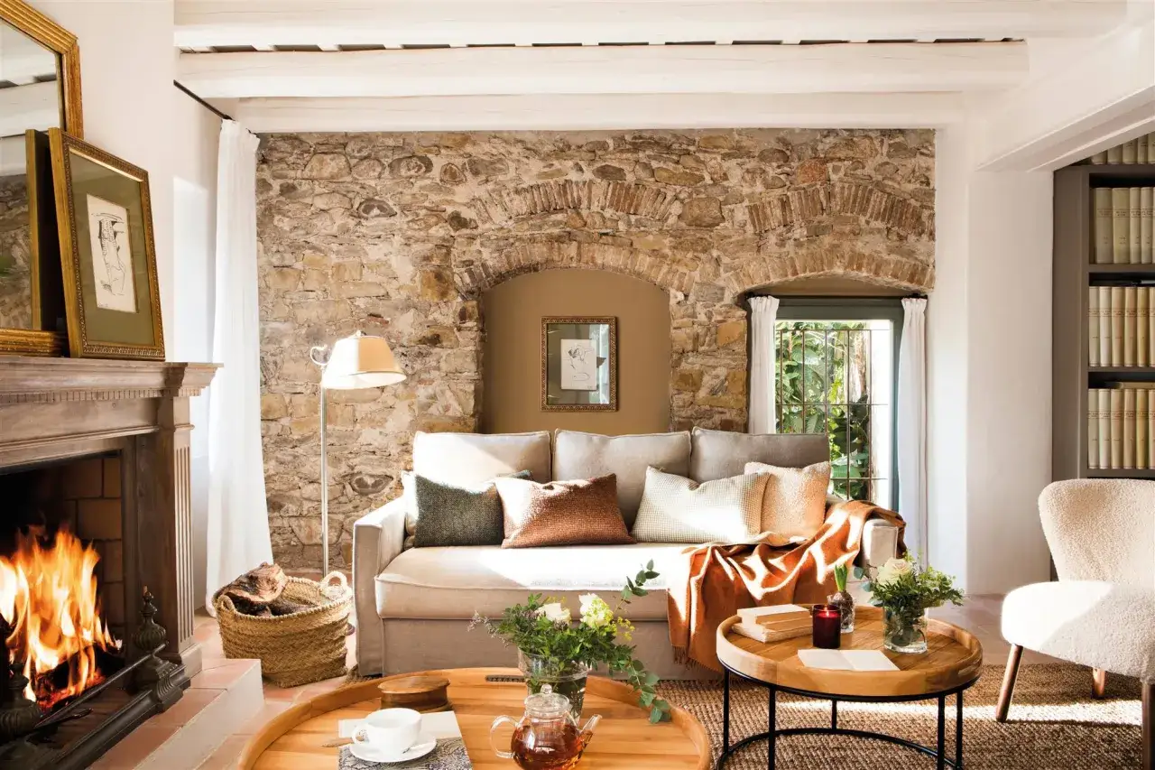 Salón rústico con chimenea encendida, sofá cómodo y detalles que inspiran para decorar paredes salón.