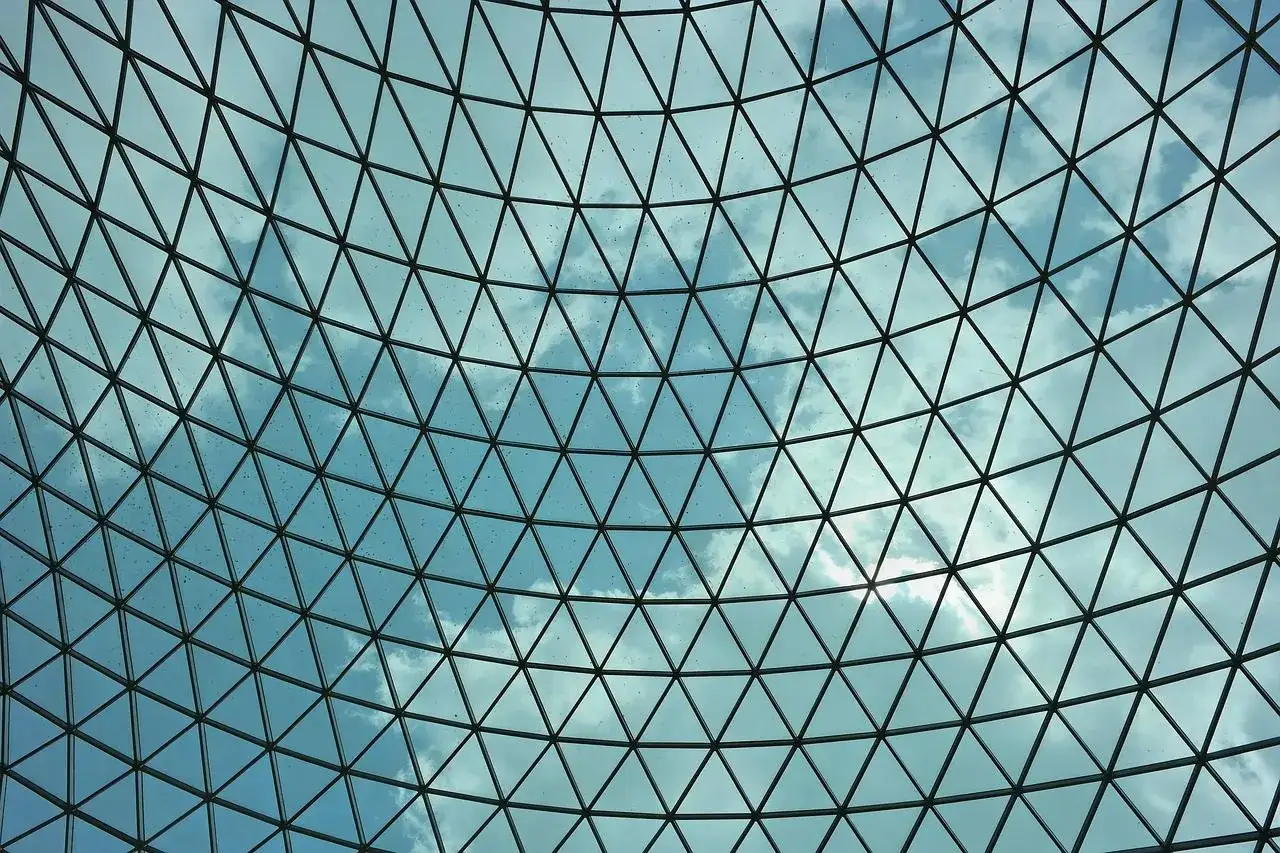 Techos de cristal inconvenientes: la lluvia deja marcas en la estructura triangular que mira al cielo nublado.