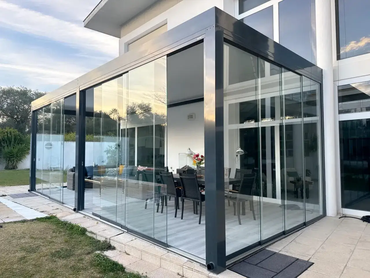 Modern glass enclosure with sliding panels, offering panoramic views but potentially presenting inconveniences with cleaning and maintenance.