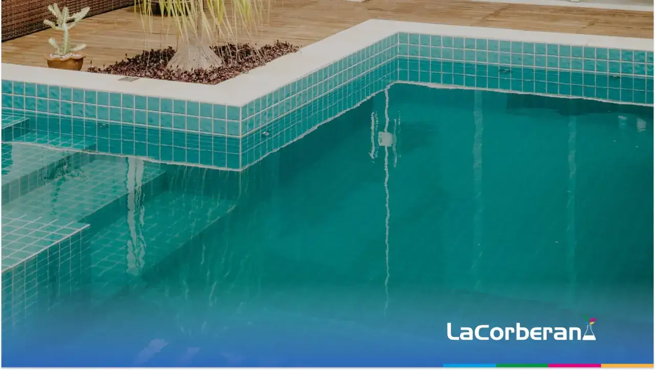 Agua de piscina blanquecina con escalones de acceso y vegetaci&oacute;n tropical.