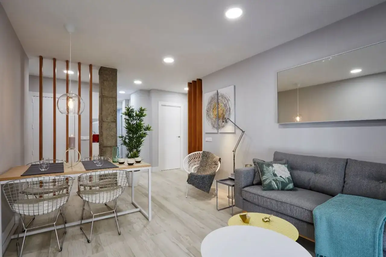 Un sal&oacute;n moderno y luminoso, ideal para dise&ntilde;ar tu hogar. Mesa de comedor, sof&aacute; gris y decoraci&oacute;n minimalista.