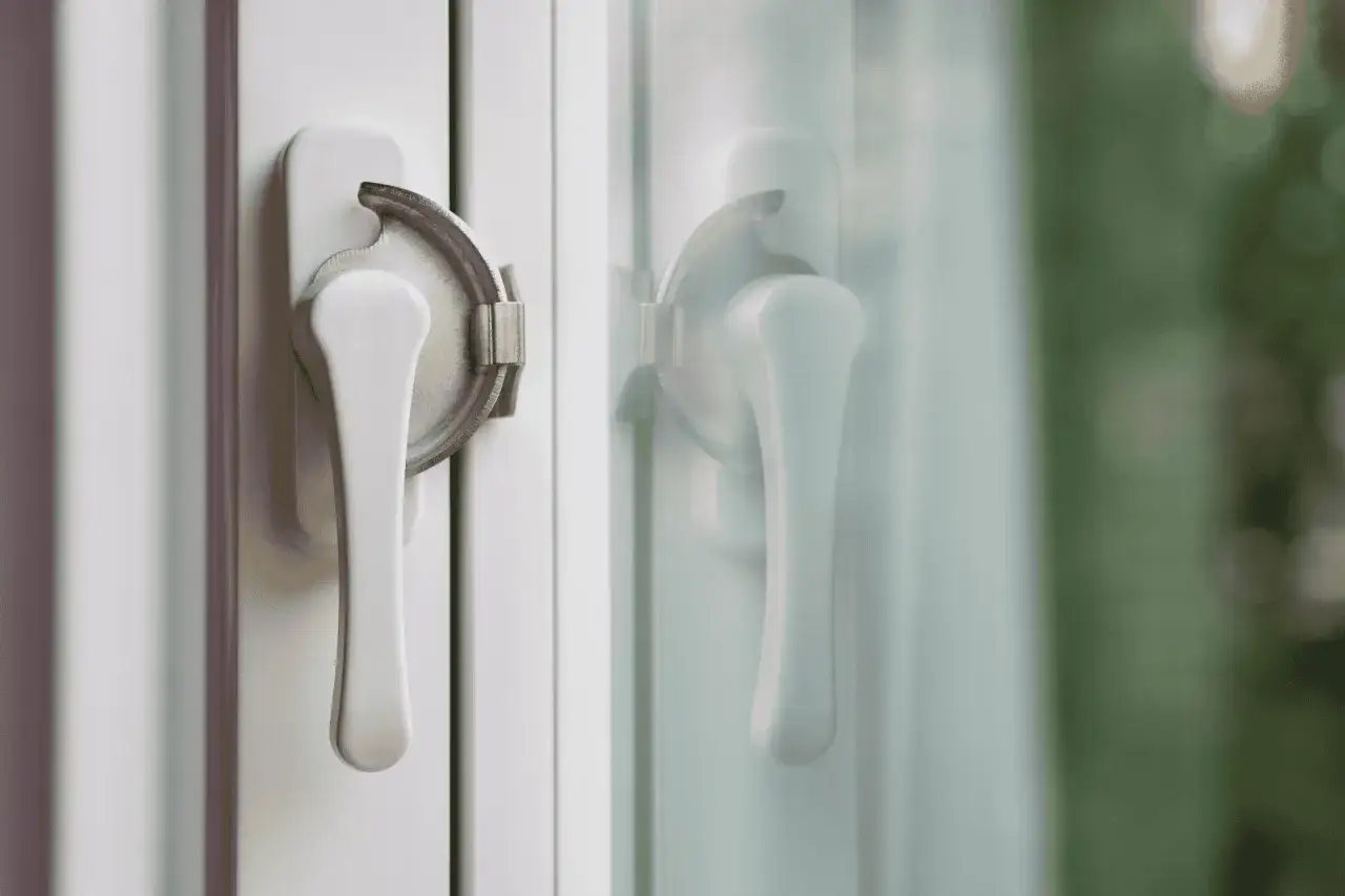 Dos manijas de ventana blancas con mecanismos de bloqueo, que garantizan cerraduras seguras para tu hogar.
