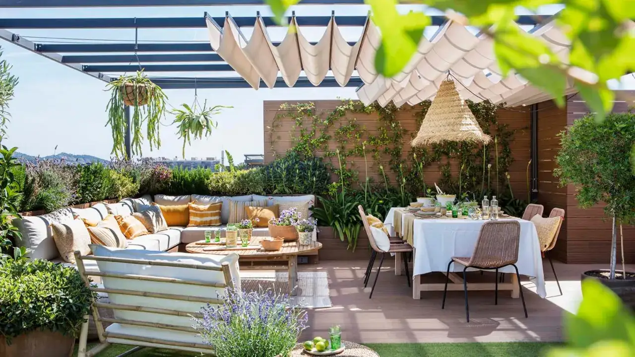Acogedora terraza &aacute;tico con zona de estar y comedor, rodeada de vegetaci&oacute;n y con vistas.