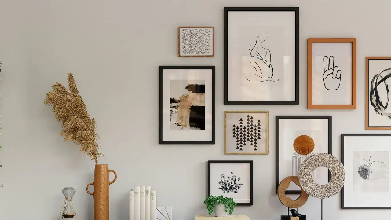Galer&iacute;a de arte moderno con varios cuadros, un jarr&oacute;n con pampas y un reloj de arena. Ideas para saber como colgar un cuadro.