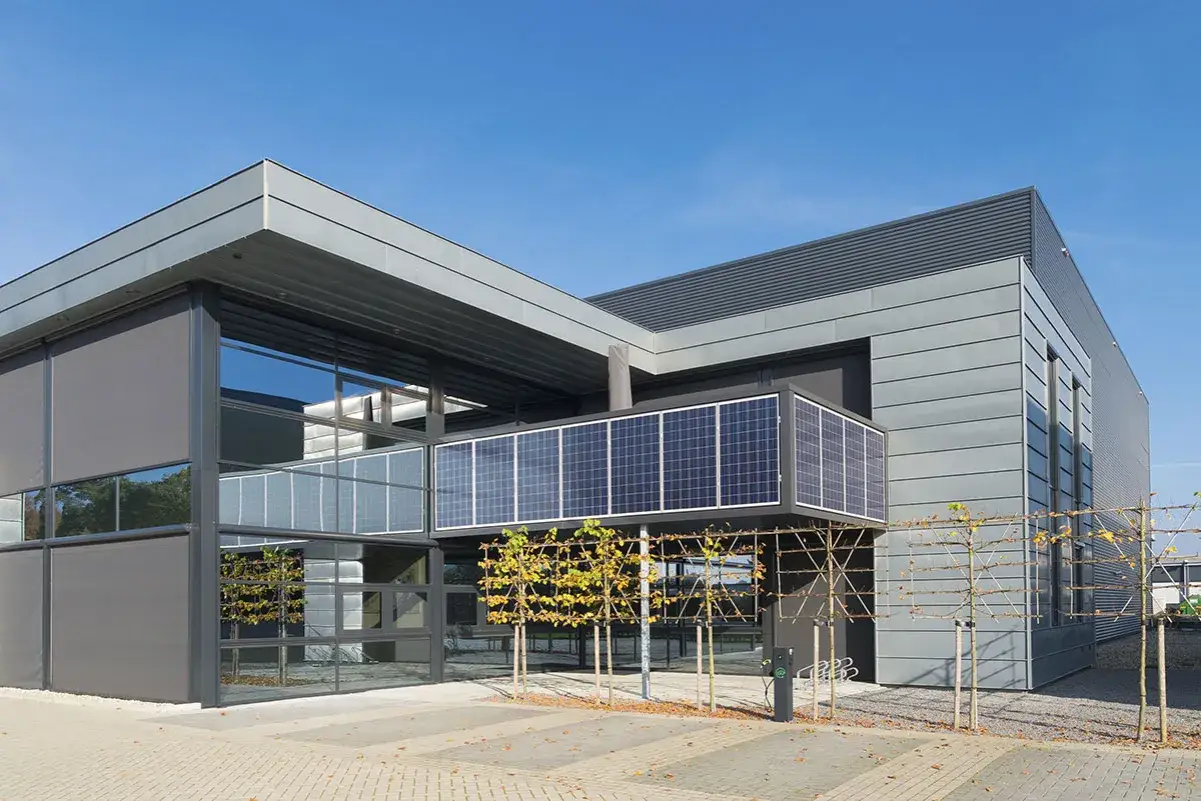 Edificio moderno con paneles de ventanas solares integrados en su fachada, capturando la energía del sol.