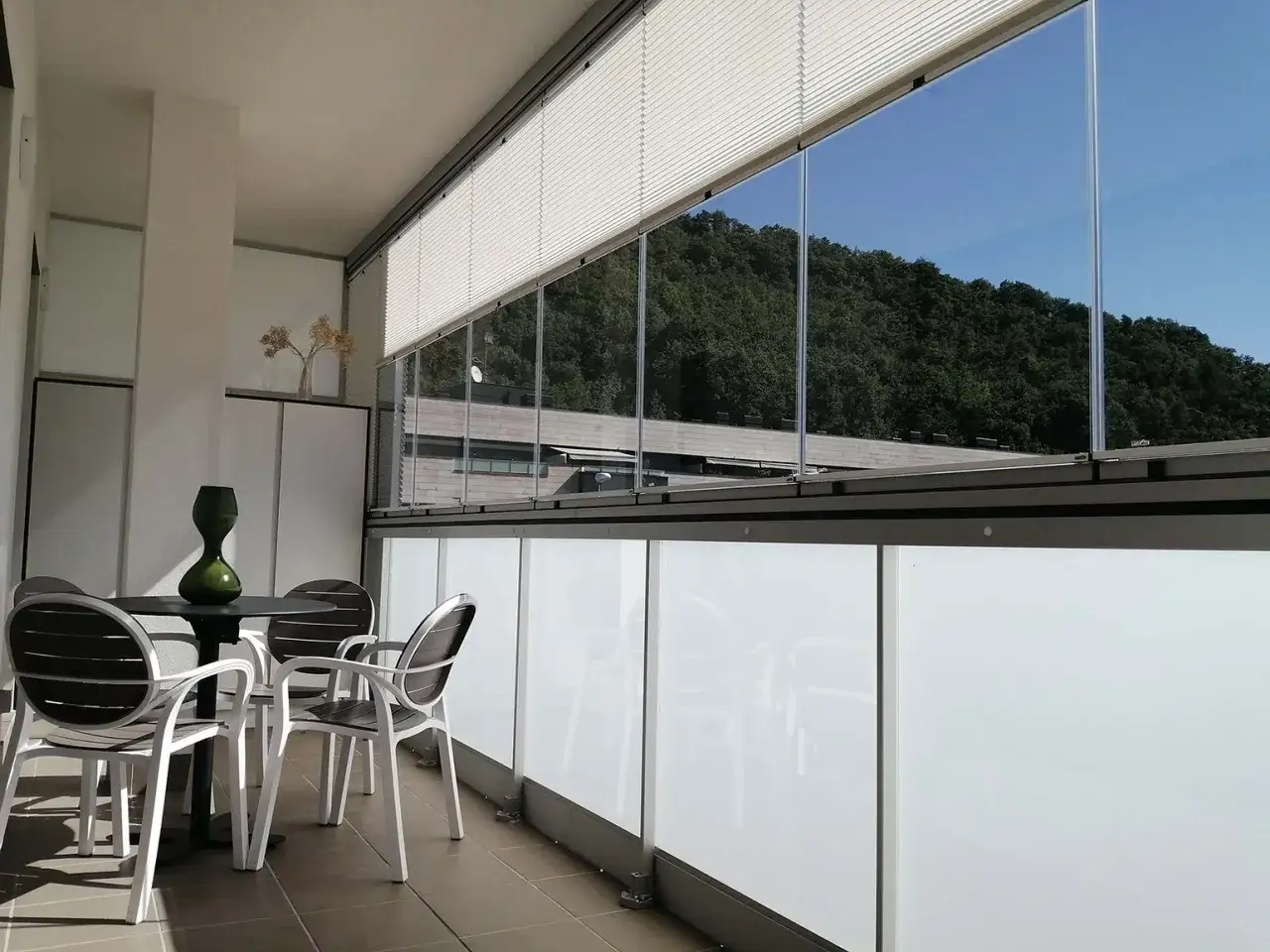 Mesa y sillas en un porche acristalado, ideal para saber como cerrar un porche para el invierno y disfrutarlo todo el año.