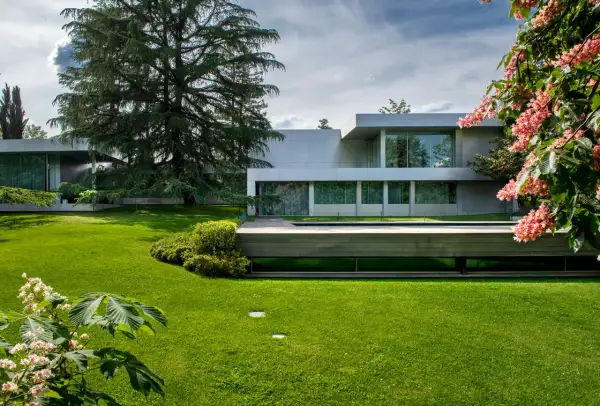 Modern villa con piscina y jardines impecables, un ejemplo de patios de lujo.