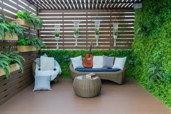 Un rincón acogedor para cerrar el patio exterior, con sofá, sillón, mesa y guitarra.