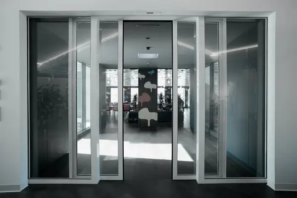 Modern interior with automatic, floor-to-ceiling ventanas correderas o abatibles, revealing a vibrant dining area with cloud-themed decor.