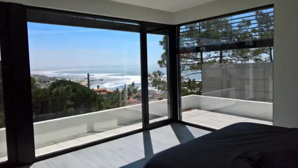 Ventana con vistas al mar, ideal para inspirar ideas para decorar ventanas. El interior minimalista contrasta con el paisaje exterior.