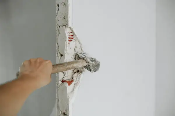 Mano golpeando un tabique con un mazo. ¡Demostrando que puedo tirar un tabique yo mismo!
