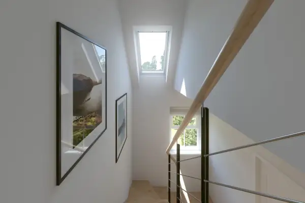 Escalera moderna con barandilla de madera y metal. Dos cuadros decoran la pared. Ventanas en pasillos interiores inundan de luz natural el espacio.